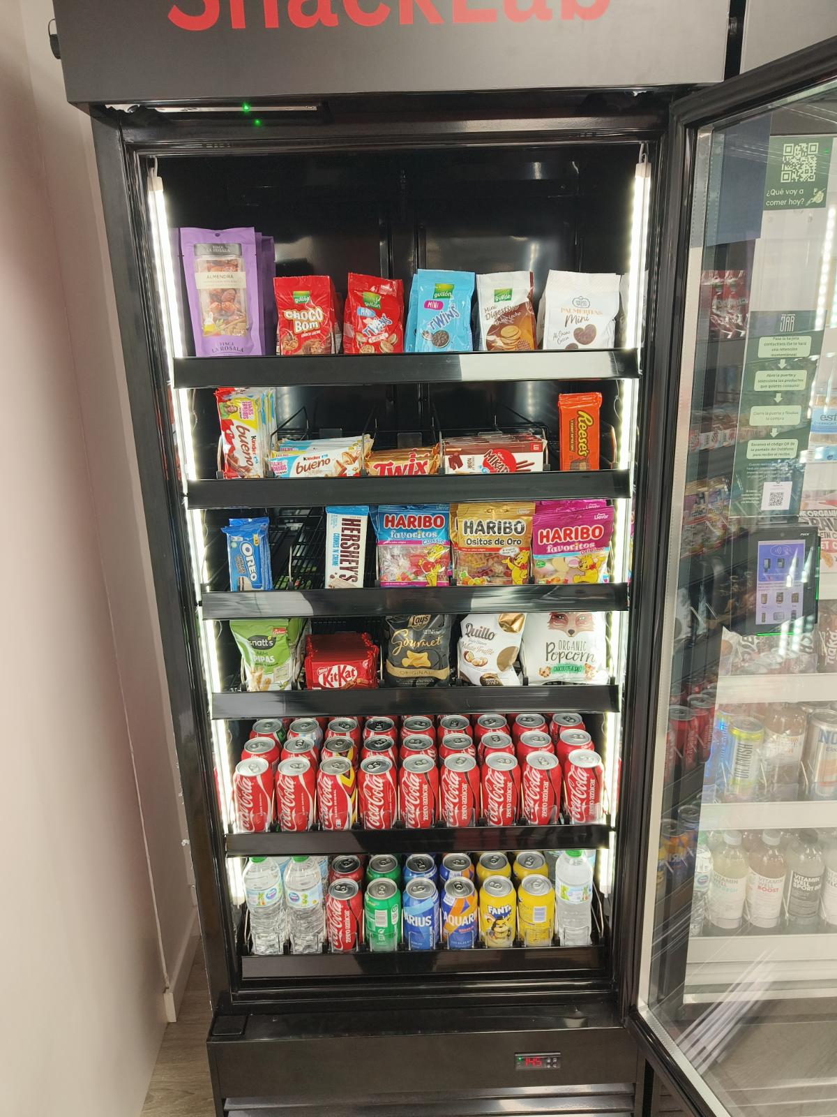 Nevera SnackLab abierta con galletas, chocolates, Haribo y bebidas